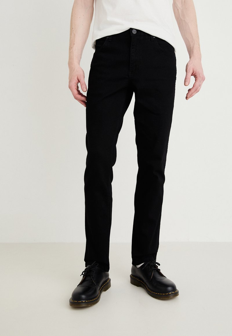 Jeans negri din denim cu o croială slim, având cinci buzunare, o textură netedă și închidere cu un nasture metalic. Asortați cu pantofi negri cu șiret.