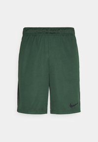 Pantalones cortos deportivos verdes hechos de tela suave con una cinturilla elástica, con acentos laterales negros y un pequeño logo negro en la parte inferior izquierda.