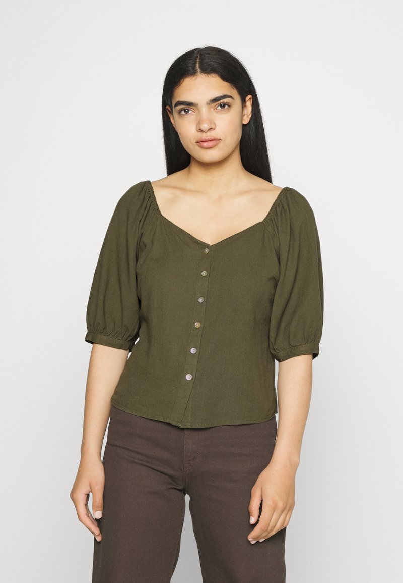 Blusa verde oliva com mangas bufantes, decote arredondado e fecho frontal com botões na mesma cor. Tecido leve.