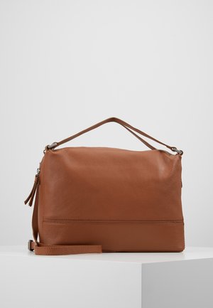 Hnědá kožená kabelka s jedním horním uchycením a odnímatelným ramenním popruhem, ležící na bílém povrchu proti jednému šedému pozadí.