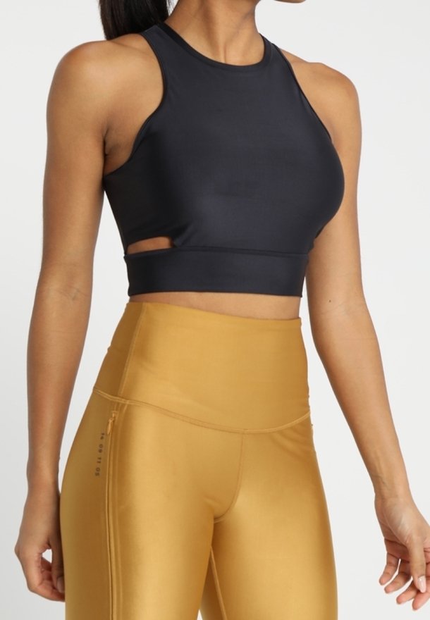 Marinefarbener Sport-BH mit Ausschnitt-Detail und glatter Textur. Kombiniert mit hochgeschnittenen, senfgelben Leggings mit einem Reißverschlussfach.