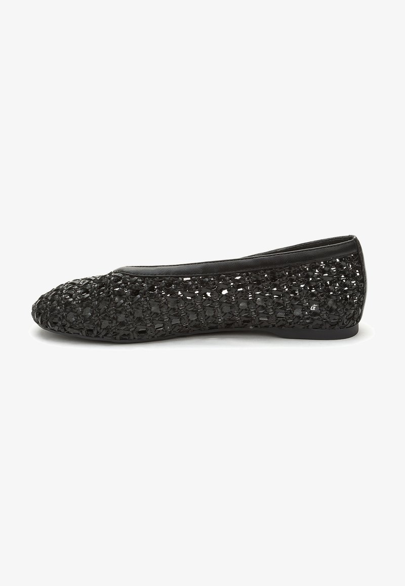 Chaussure noire plate avec un dessus en tissu texturé tissé et des bordures en cuir lisse. Bout arrondi et semelle basse pour le confort et la flexibilité.