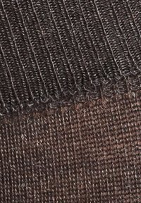 Textured fabric in dark brown, featuring a ribbed top section and a tightly woven bottom, with visible stitching along the edge.