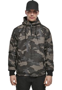 Chaqueta de pullover de camuflaje con capucha ajustable, tonos gris oscuro y verde, bolsillos con cremallera y puños elásticos. Material sintético suave.