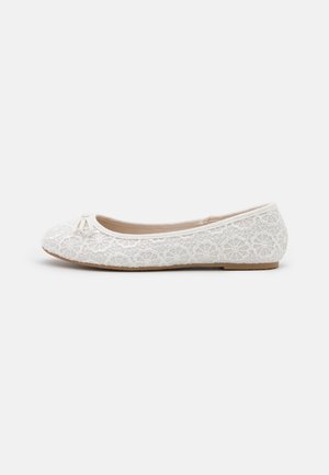 Ballerine plate en dentelle blanche avec motifs floraux, petit nœud à l’avant et semelle fine couleur beige clair.
