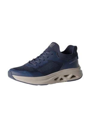 Zapatilla deportiva azul marino y beige con parte superior de malla, suela acolchada con recortes triangulares y la marca "KOROSHI" en el lateral.