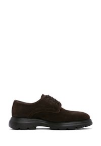Des chaussures oxford en suède marron avec un bout arrondi, un laçage à cinq oeillets et une épaisse semelle en caoutchouc noir. Texture lisse avec un minimum de détails de couture.