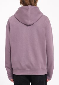 Sudadera con capucha en lavanda clara, hecha de una tela suave. Presenta un capuchón con cordón, puños acanalados y un ajuste relajado. Diseño simple sin patrones.