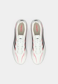 Λευκά ποδοσφαιρικά παπούτσια με μαύρες ρίγες και ροζ λεπτομέρειες, με απαλή υφή, σχέδιο με κορδόνια και μαξιλαρωμένο εσωτερικό για άνεση.