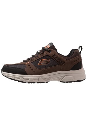 Brown and black lace-up sneaker with thick beige sole and orange "S" logo on side, designed for casual or athletic wear.