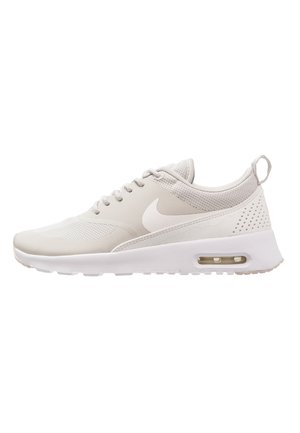 Baskets Nike beige clair avec embout en mesh, fermeture à lacets sur l’avant, semelle amortie avec unité d’air visible et languette au talon.