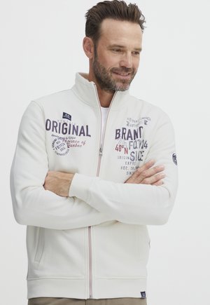 Weißer Reißverschluss-Hoodie mit verschiedenen Drucken in Dunkelblau und Rot. Verfügt über einen hohen Kragen, seitliche Taschen sowie gerippte Bündchen und Saum.