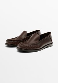 Bruine leren instappers met een moccasinontwerp, voorzien van stiksels, een gladde textuur en een lage zool.