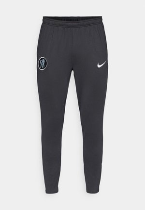 Grå Nike joggebukser med elastisk midje, smale ben, et Chelsea FC-logo på venstre lår og en kontrasterende hvit Nike-swoosh.