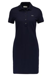Navy blue polo dress made of cotton, featuring a collared neckline, button placket, short sleeves, and a Lacoste logo on the chest.