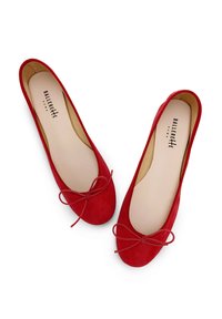 Bailarinas de ante rojo con punta redondeada y detalle de lazo. Presentan un forro interior suave y una suela delgada y flexible.