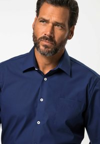 Námořnická modrá košile na knoflíky z texturované tkaniny, s jednou náprsní kapsou a bílými knoflíky, s klasickým límcovým provedením.