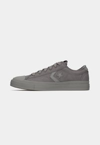 Gray suede sneaker with a round toe, flat rubber sole, lace-up closure, and star accent on the side. Simple, low-profile design.