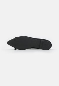 Sandal de cor preta com bico fino e sola fina e flexível. O material superior parece liso, com detalhes mínimos.