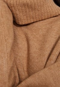 Tissu de pull en tricot marron, présentant une texture côtelée et une finition lisse, avec un col plié et une apparence douce et chaude.