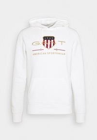 Sudadera blanca de algodón con un bolsillo frontal, que presenta un logo de color con un diseño de escudo y el texto "1949 AMERICAN SPORTSWEAR."
