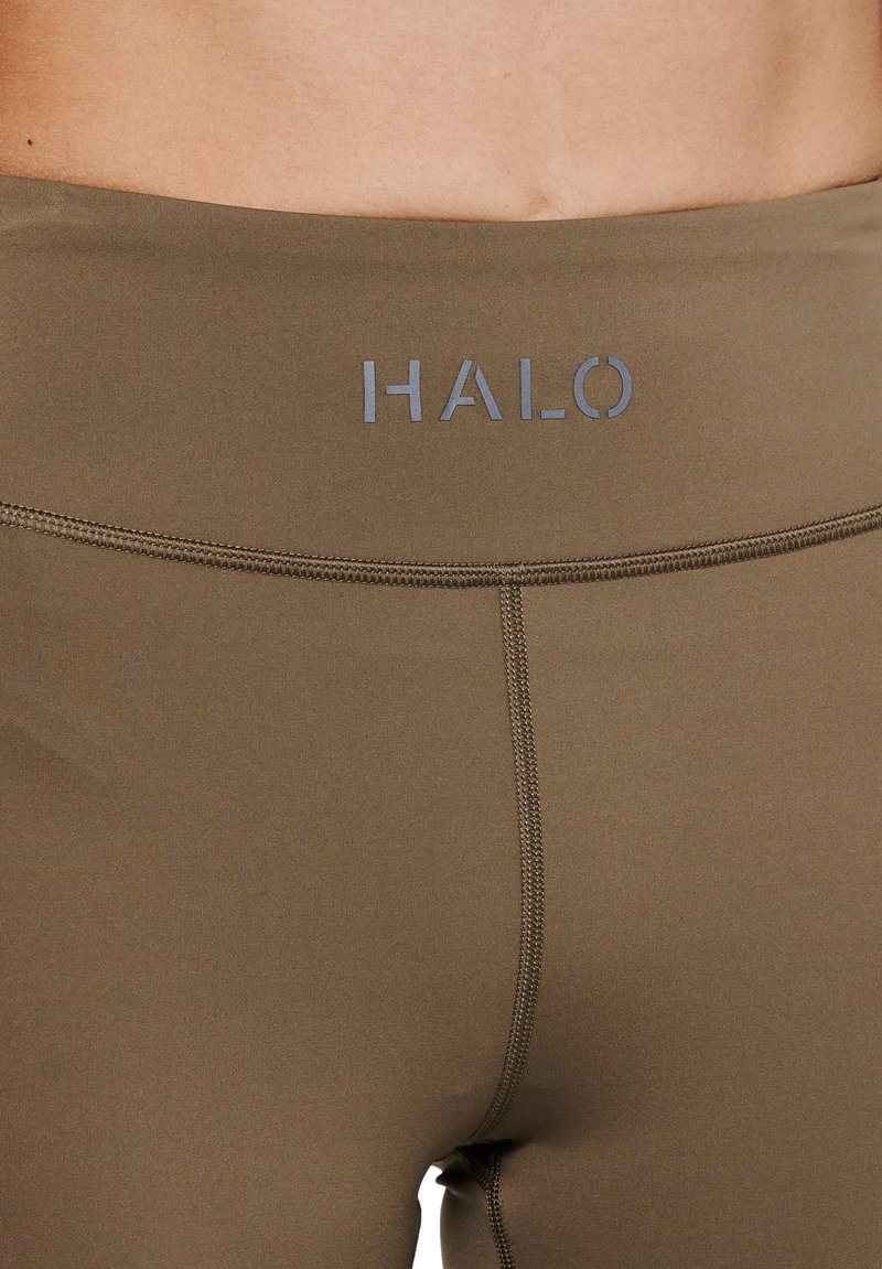 Olijfgroen leggings met een hoge tailleband, voorzien van een "HALO" logo in lichtgrijs. Zachte textuur en platte naden voor comfort.