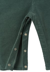 Dark green corduroy fabric with a ribbed texture, featuring snap fasteners along the side for adjustable openings.