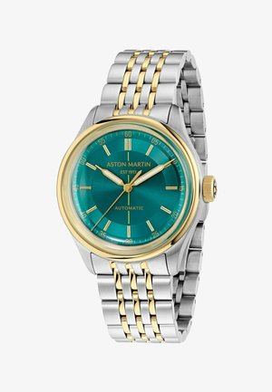 Zweifarbige Armbanduhr aus silber- und goldfarbenem Metall mit türkisfarbenem Zifferblatt, goldenen Stundenmarkierungen und Zeigern, die 10:08 anzeigen, beschriftet mit Aston Martin Automatic.