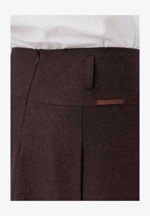 Brązowe wełniane spodnie o dopasowanym kroju, z bocznym zamkiem błyskawicznym, małymi szlufkami na pasek oraz tłoczonym metkiem oznaczonym "ANATAKA."