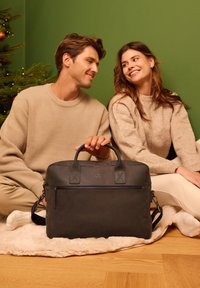 Zwarte leren laptoptas met dubbele handgrepen, voorvak met ritssluiting en afneembare schouderriem. Getextureerd oppervlak met subtiel merkdetail.