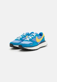 Blue and yellow athletic shoes with suede and mesh materials; featuring white laces, a textured sole, and a prominent yellow logo on the side.