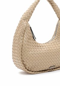 Beżowa torebka ze splatanego leather o okrągłym kształcie, z zamknięciem na zamek i teksturowaną powierzchnią. Ozdobiona eleganckim srebrnym zamkiem.
