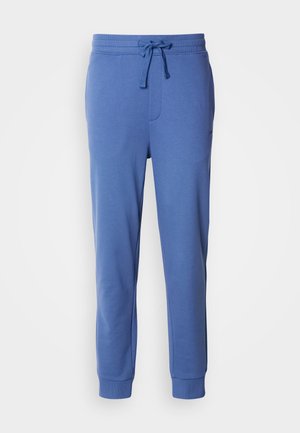Blå joggebukser laget av myk bomullsblanding. Har elastisk midje med snor og tettsittende mansjetter for en snug passform. Ingen synlige mønstre.