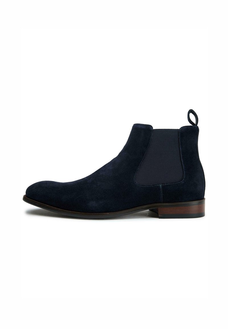 Navy suede Chelsea boots with elastic side panels and a pull tab. Features a rounded toe and a low stacked heel for added style.