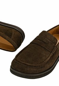 Paire de mocassins en daim marron foncé avec bout rond, semelle en caoutchouc noir et détails cousus sur la partie supérieure.