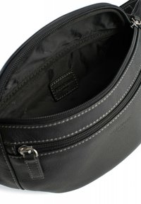 Borsa in pelle nera con forma rotonda, chiusura con cerniera e cuciture a contrasto. L'interno presenta una fodera in tessuto liscio e una tasca piccola.