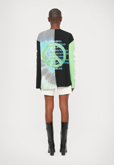 Majica dugih rukava s crnom podlogom, zelenim naglascima i dizajnom u tehnici tie-dye. Na leđima se nalazi tekst u raznobojnim nijansama i kružna grafika.