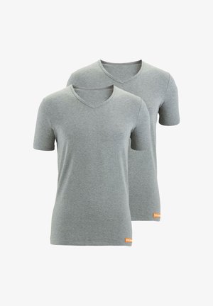 Dwie gładkie, jasnoszare koszulki T-shirt z krótkim rękawem w serek, ułożone jedna na drugiej, każda z małą pomarańczową etykietą marki na dolnym końcu.