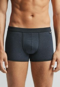 Boxer briefs de color azul oscuro con una textura acanalada, cinturilla elástica y sin patrones ni gráficos visibles. Tejido lavable a máquina.