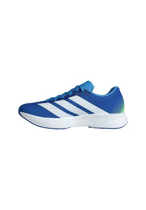 Zapatilla deportiva azul con tres franjas blancas, suela blanca y un detalle degradado verde en el talón, mostrada de perfil lateral mirando hacia la izquierda.