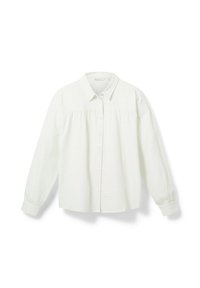 Camicia bianca a maniche lunghe realizzata in tessuto morbido, con chiusura a bottoni, colletto e dettagli arricciati sul petto.