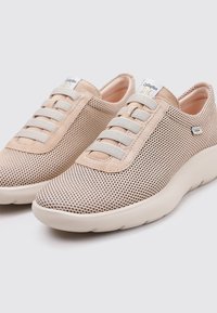 Zapatillas ligeras de malla beige con cordones elásticos grises, un interior suave y una suela blanca acolchada para mayor comodidad y transpirabilidad.