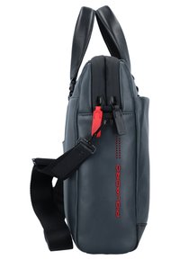 Bolso de cuero gris con asas dobles, correa ajustable, cierre de cremallera y acentos rojos; presenta una forma rectangular elegante y una textura suave.