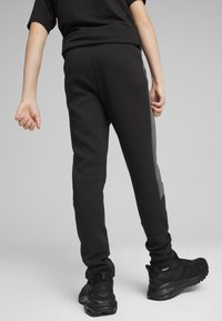 Puma EVOSTRIPE YOUTH - Pantalones deportivos - black
