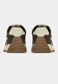 Καφέ αθλητικά παπούτσια με στρωματοποιημένο σχέδιο, μπεζ φτέρνα και ανοιχτό καφέ σόλα. Υφασμένο επάνω μέρος με ομαλή υφή.