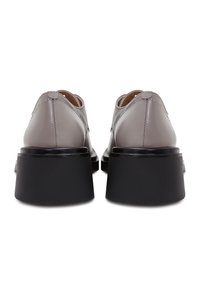 Grijze leren schoenen met een ronde neus, met een stevige zwarte blokhak en zichtbare stiksels aan de achterkant.