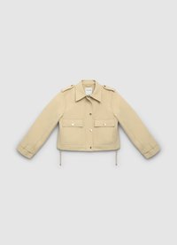 Veste beige clair avec un design structuré, épaulettes de style militaire, deux poches à rabat à l'avant et cordons de serrage ajustables à l'ourlet.