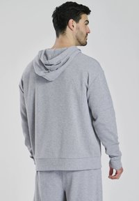 Grå hætte sweatshirt lavet af tekstureret stof, med en afslappet pasform, ribbede manchetter og en kengurulomme.