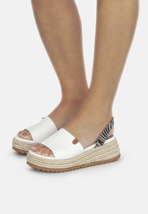 Witte espadrillesandalen met open tenen, een platformzool van gestructureerd jute en een gestreepte stoffen accent aan de achterkant.