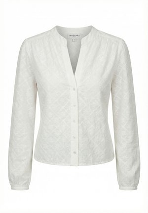 Blusa blanca de manga larga con sutil estampado floral bordado, escote redondo con abertura en V y cierre frontal de botones.